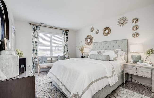 A bedroom with a large bed, a nightstand, and a dresser.