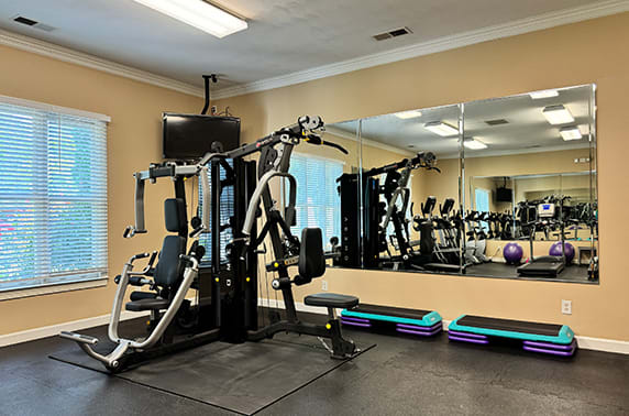 a gym with exercise equipment and a mirror