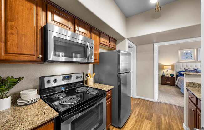A kitchen with a black stove top oven and a black microwave above it.