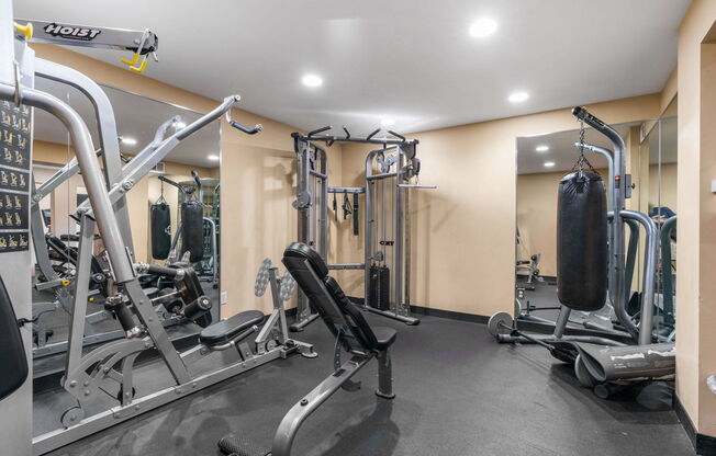 A gym with a variety of equipment including treadmills, weights, and exercise machines.