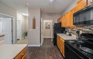 Galley Kitchen leading to laundry room at Sugarloaf Crossings Apartments in Lawrenceville, GA 30046