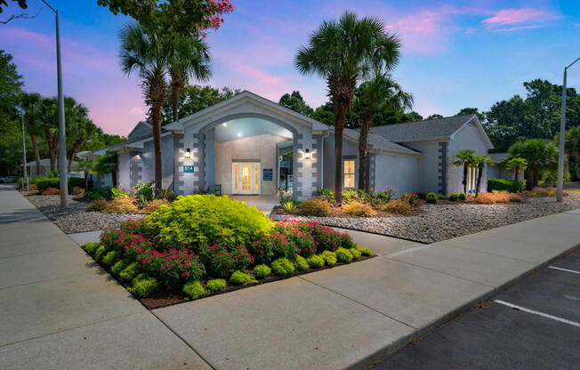 a house with a sidewalk and palm trees in front of it