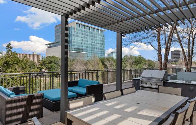 a patio with a table and chairs and a grill