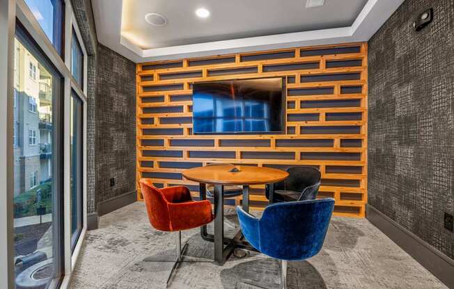 A room with a wooden wall and a table with chairs.