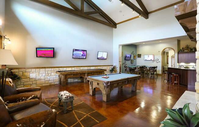 A living room with a pool table and a fireplace.