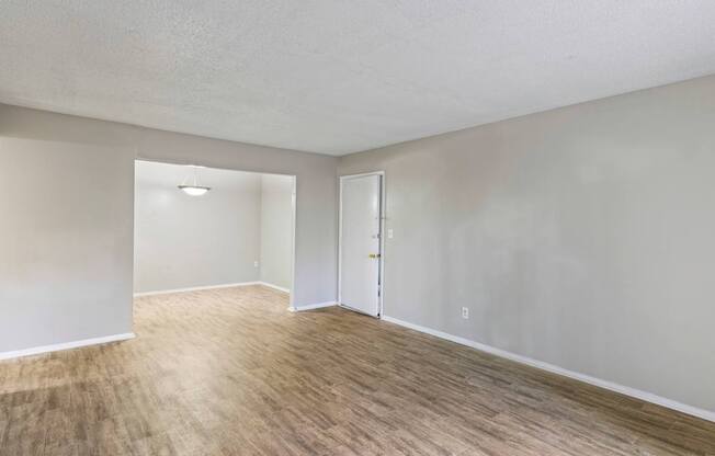 A room with wooden flooring and two doors.