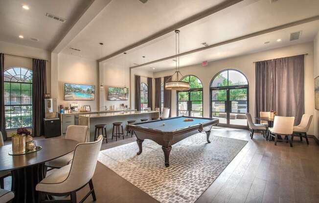 A large room with a pool table and a bar.