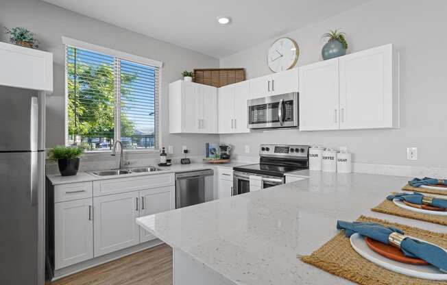 a large kitchen with white cabinets and stainless steel appliances