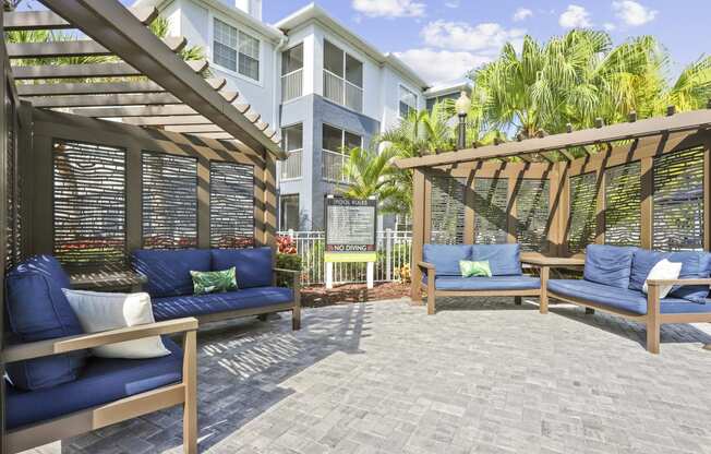 a patio with couches and chairs and a building in the background