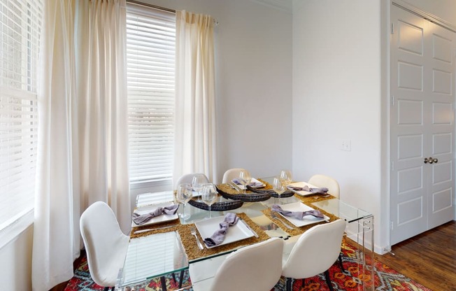 a dining room with a glass table and white chairs