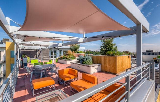 a rooftop terrace with orange chairs and tables