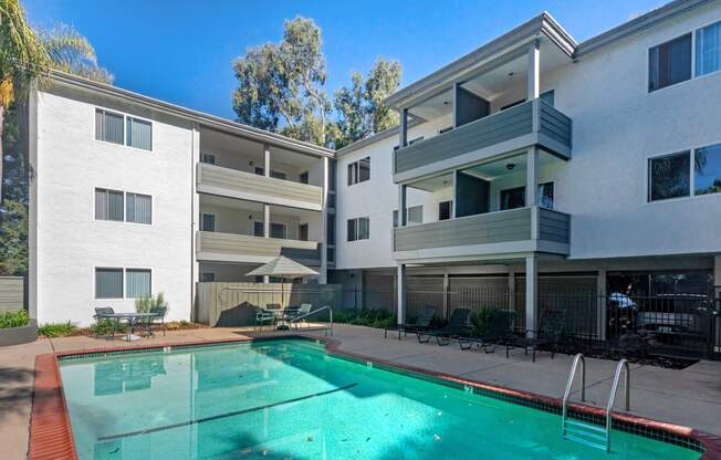 an apartment building with a pool in front of it