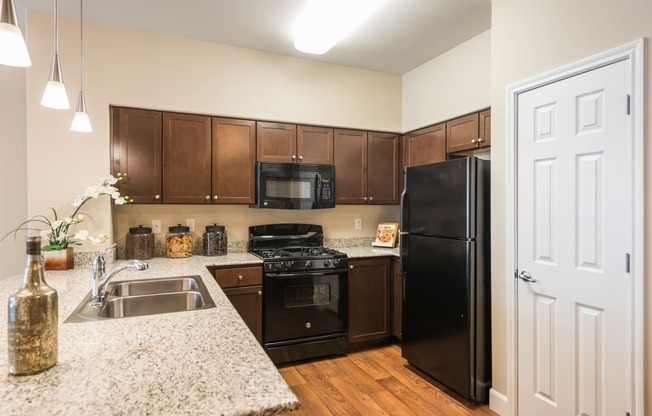 a kitchen with black appliances and granite counter tops