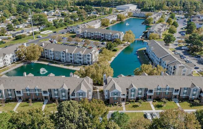 an aerial view of apartments with a lake behind them
