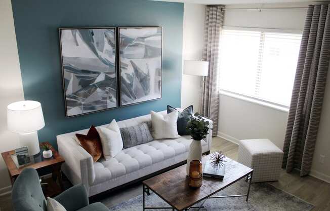 living room with large window, accent wall, and model furniture  at Huntsville Landing Apartments, Alabama, 35806