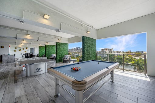 a games room with a pool table and a view of the city