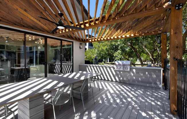 a covered patio with a table and chairs