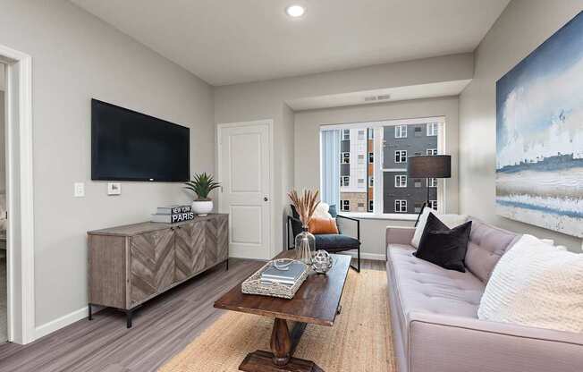 A living room with a couch, a coffee table, and a large painting on the wall.