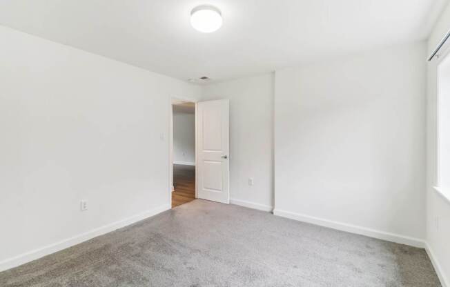 a living room with a carpeted floor and white walls