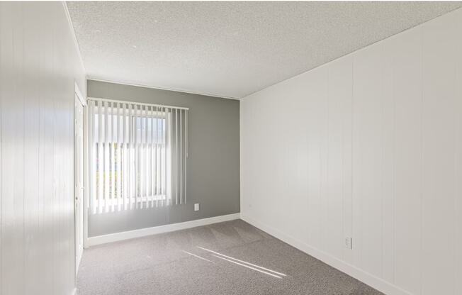 an empty bedroom with a large window