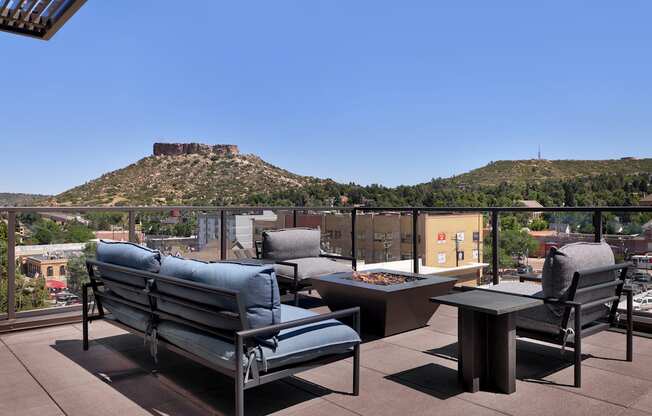A patio with a table and chairs overlooking a mountain.