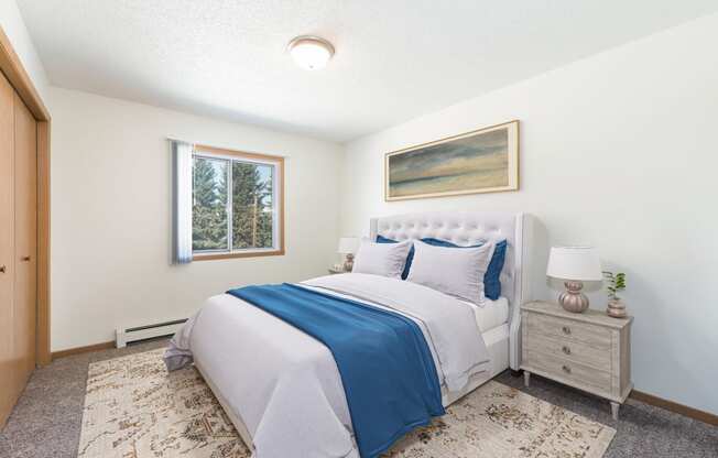 Sierra Ridge Apartments in Bismarck, ND | The room showcases a peaceful ambiance with a cozy bed, stylish furnishings, and soft lighting from the window
