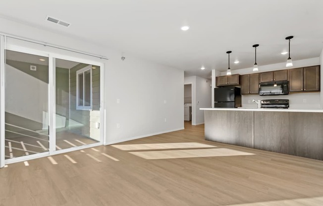 A modern kitchen with a white countertop and a wooden floor.