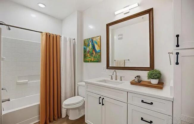 A bathroom with a white sink and a white toilet.