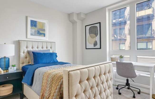 a bedroom with a bed and a desk with a chair