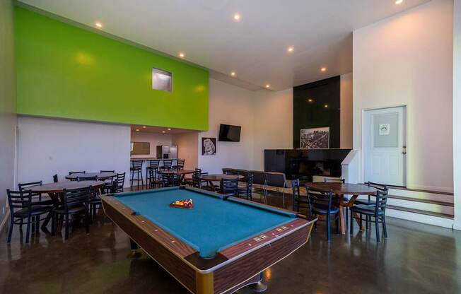 A pool table is in the middle of the room.