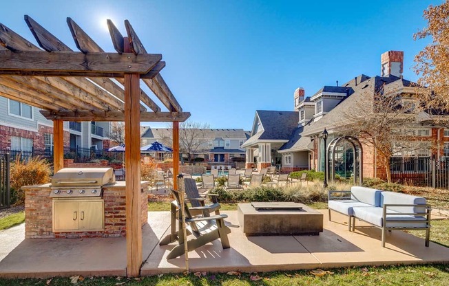 a backyard with a barbecue grill and a patio with a table and chairs