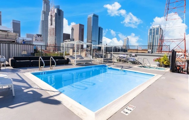 the pool on the roof of a building with a city in the background