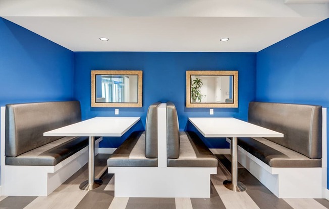 A blue and white restaurant with two tables and two benches.