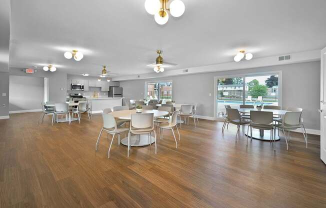 Resident clubhouse with a kitchen, seating, community tables, and bright natural light at Warren Woods Apartments in Warren, MI.