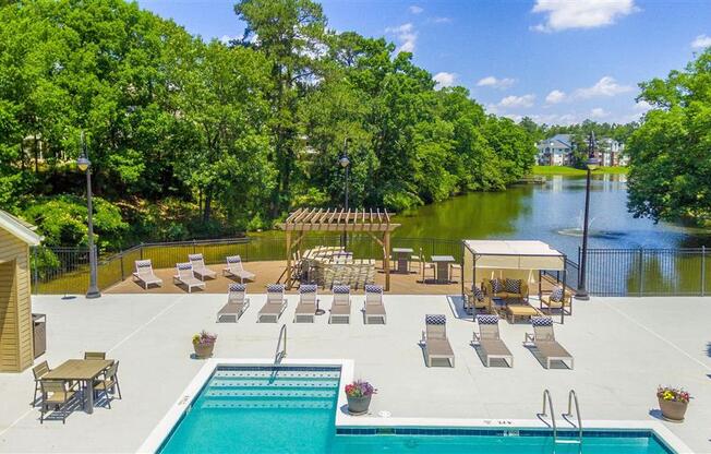 an aerial view of a swimming pool and patio with lounge chairs