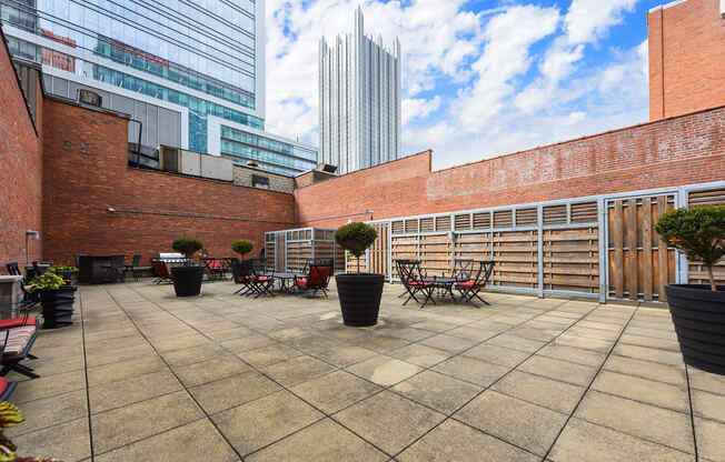 a terrace with tables and chairs and a building in the background