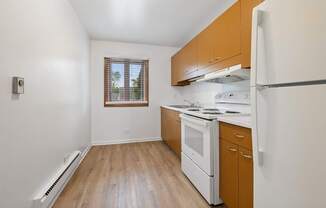 A kitchen with white appliances and wooden cabinets.