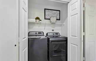 A small laundry room with a washer and dryer.