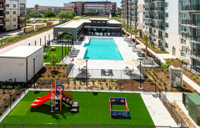 an aerial view of an apartment complex with a swimming pool and a playground