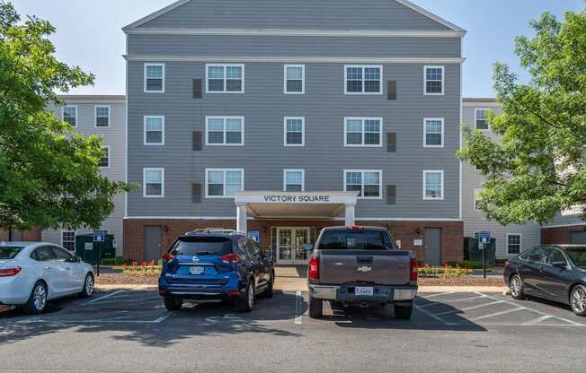 a parking lot with cars in front of an apartment building