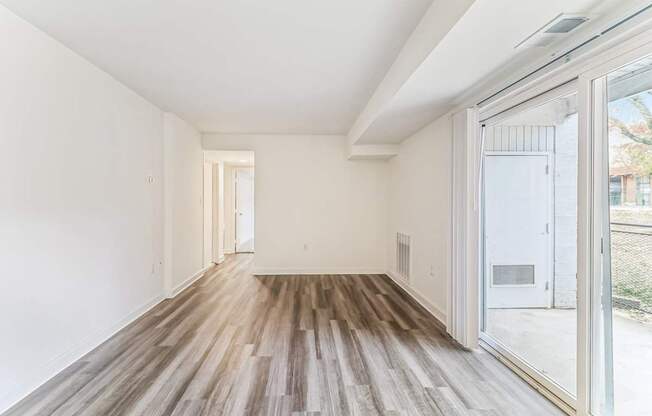 a living room with wood floors and a large glass door