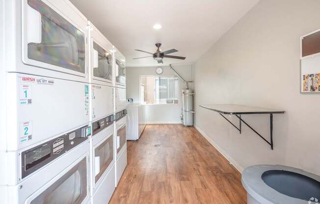 A laundry room with a washer and dryer on the left and a toilet on the right.
