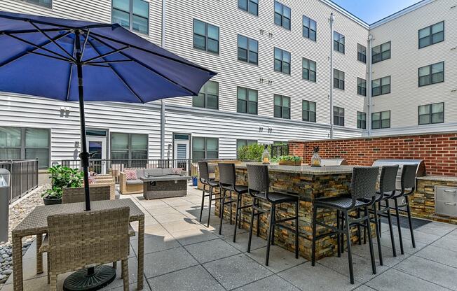 Courtyard patio with a bar and tables with chairs and umbrellas at The View at Old City, Philadelphia