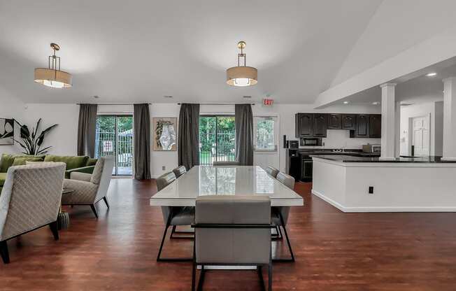 a kitchen and lounge room with a table and chairs in a clubhouse in Greenwood Apartments