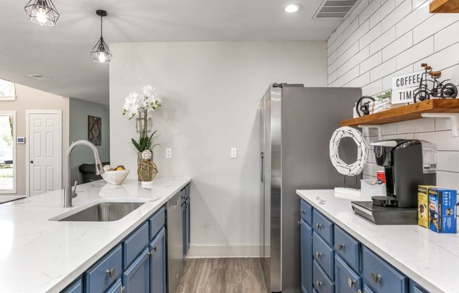a kitchen with white countertops and blue cabinets