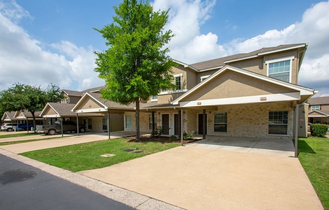 A row of houses with a tree in front of the first one.