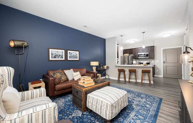 a living room with a couch and a chair in front of a kitchen