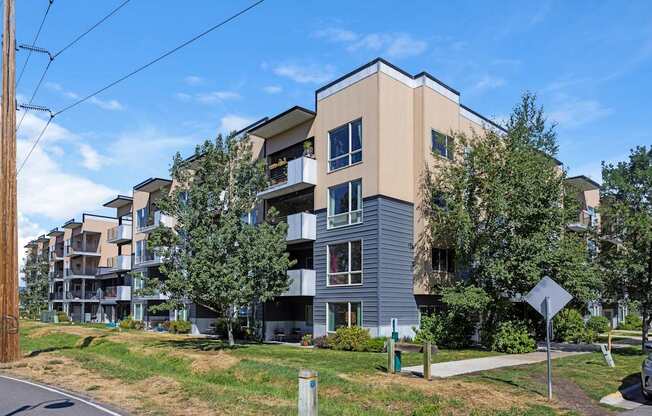 A modern apartment building with a mix of beige and grey exterior.