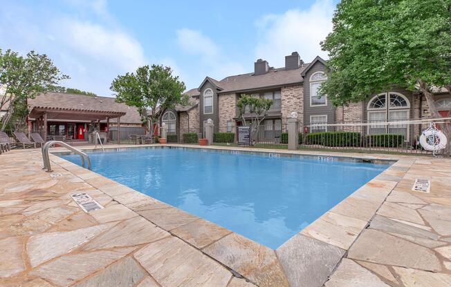 a house with a pool in front of a brick building