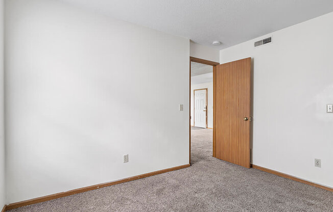 a bedroom with white walls and a wooden door